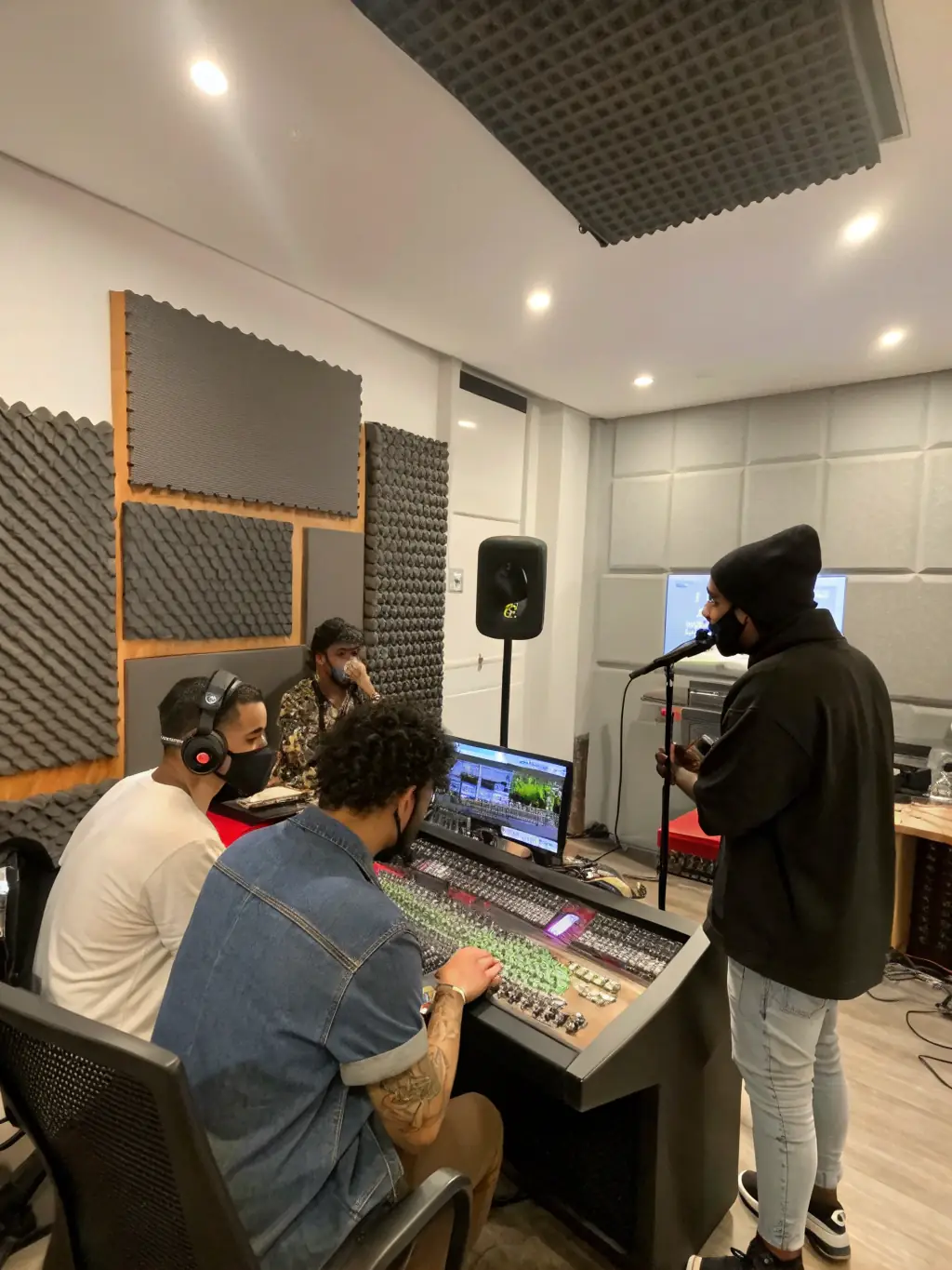 A recording studio session at BANANAS RECORDS, with artists and producers collaborating to create high-quality music, emphasizing the organization's commitment to artistic excellence.